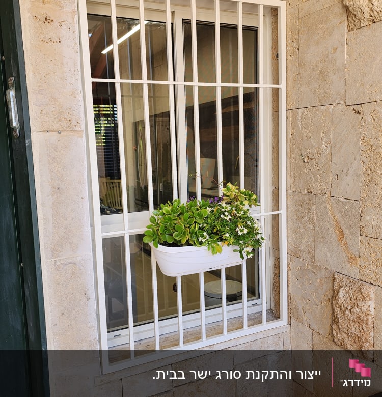 חלון עם סורגים לבנים ועציץ תלוי